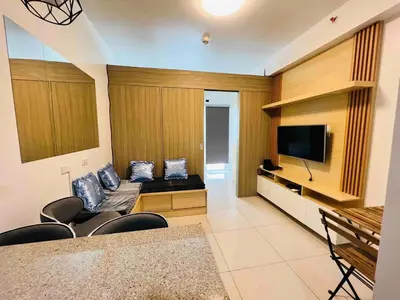 a living room with a couch and a flat screen tv at D Crib at Breeze Residences Pasay City Philippines in Manila