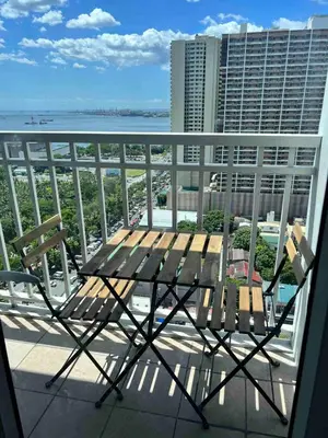 a bench on a balcony with a view of the ocean at D Crib at Breeze Residences Pasay City Philippines in Manila
