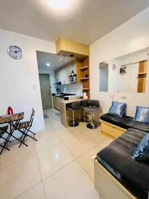 a living room and kitchen with a couch and a table at D Crib at Breeze Residences Pasay City Philippines in Manila