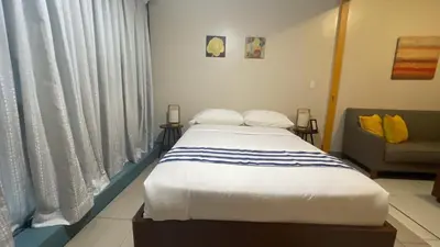 a bedroom with a large bed and a couch at Full-Serviced Residential Apartment in One Uptown Residences, BGC in Manila