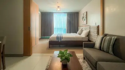a hotel room with a bed and a couch at Full-Serviced Residential Apartment in One Uptown Residences, BGC in Manila