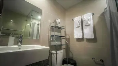 a bathroom with a sink and a toilet and a mirror at Full-Serviced Residential Apartment in One Uptown Residences, BGC in Manila