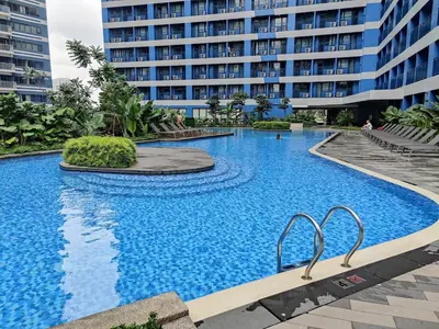 a large swimming pool in front of a building at Stunning 2BR Condo in AIR Residences Makati High Floor and WFH with 300Mbps Wifi in Manila