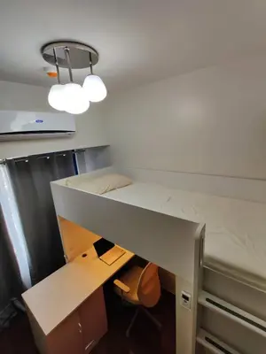 a dorm room with a bed and a desk at Stunning 2BR Condo in AIR Residences Makati High Floor and WFH with 300Mbps Wifi in Manila