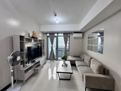 a living room with a couch and a tv at 2 Bedroom with Balcony in Manila
