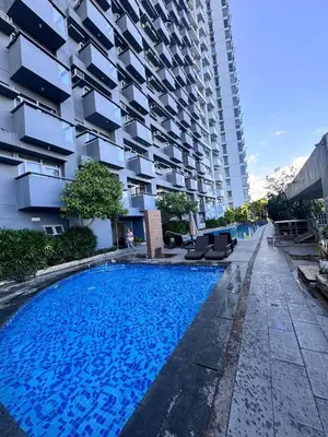 a swimming pool in front of a building at 2 Bedroom with Balcony in Manila