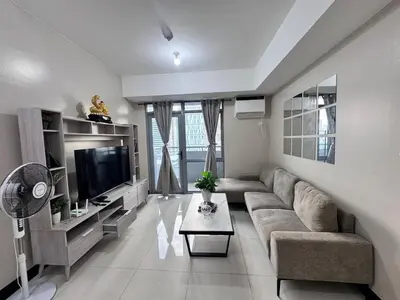 a living room with a couch and a tv at 2 Bedroom with Balcony in Manila