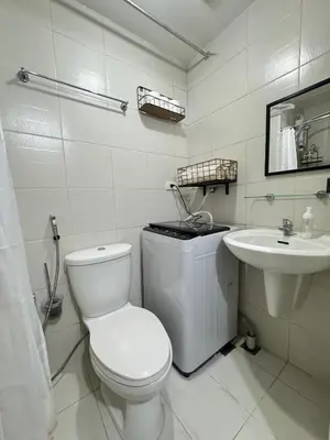 a white bathroom with a toilet and a sink at Jazz Residences Tower B in Manila