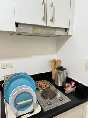 a kitchen with a stove with a blue plate on it at Jazz Residences Tower B in Manila