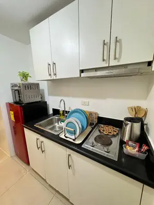 a kitchen with a sink and a stove top oven at Jazz Residences Tower B in Manila