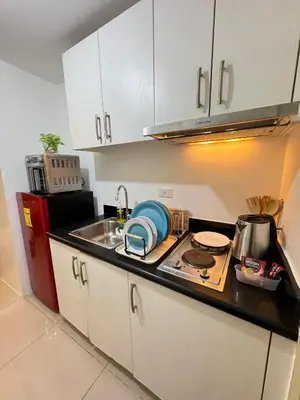 a kitchen with a sink and a stove top oven at Jazz Residences Tower B in Manila