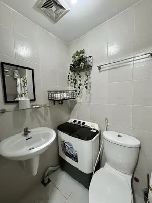 a white bathroom with a toilet and a sink at Jazz Residences Tower B in Manila