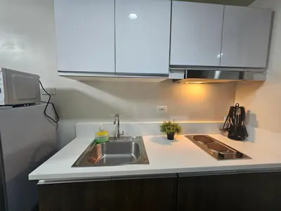 a kitchen with a sink and a refrigerator at Air Residences Makati Sage Haven in Manila