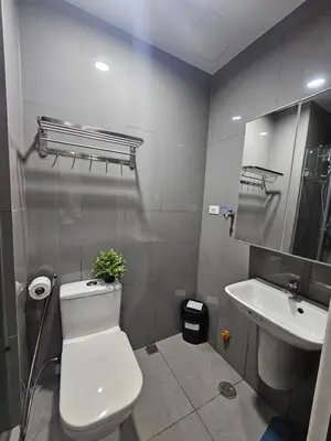 a bathroom with a white toilet and a sink at Air Residences Makati Sage Haven in Manila