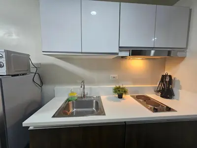 a kitchen with a sink and a refrigerator at Air Residences Makati Sage Haven in Manila