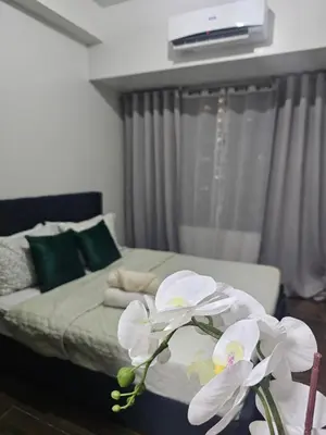 a bedroom with a bed with white flowers on it at Air Residences Makati Sage Haven in Manila