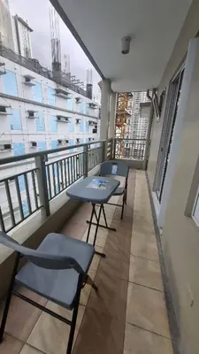 a balcony with two tables and chairs on a building at The Villa Staycation at La Verti Residences in Manila