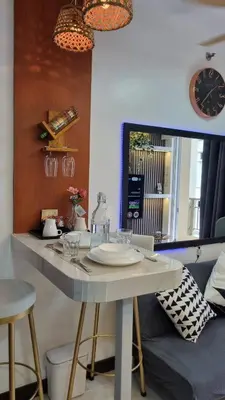 a kitchen with a table with chairs and a clock at The Villa Staycation at La Verti Residences in Manila