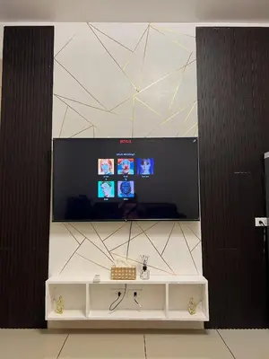 a flat screen tv on a wall with a white table at Sea Residences MOA Pasay City- Kirk in Manila