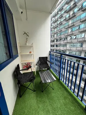 a balcony with two chairs and a table and a building at Sea Residences MOA Pasay City- Kirk in Manila