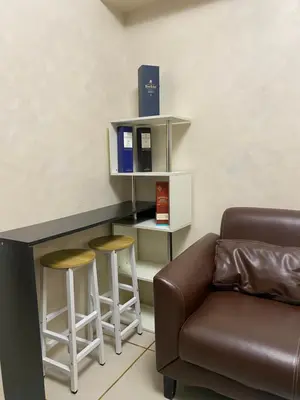 a living room with a couch and a counter with stools at Sea Residences MOA Pasay City- Kirk in Manila