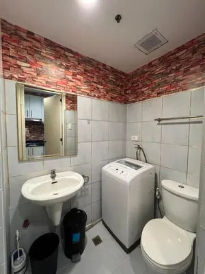 a bathroom with a toilet and a sink and a washing machine at Sea Residences MOA Pasay City- Kirk in Manila