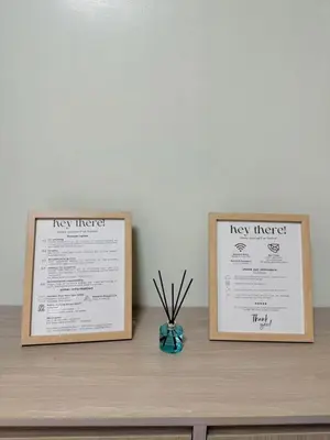 two certificates on top of a wooden shelf with a table at Budget Condo near Airport and Mall of Asia in Manila