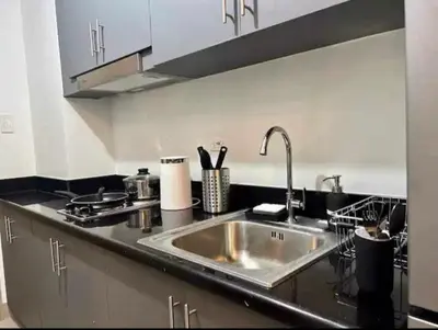 a kitchen with a sink and a counter top at Budget Condo near Airport and Mall of Asia in Manila