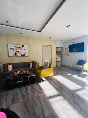 a living room with a couch and a yellow chair at Tulip Garden Condominium Southwoods in Biñan