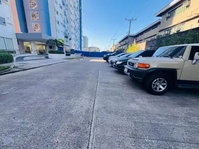 a street with cars parked in a parking lot at Tulip Garden Condominium Southwoods in Biñan