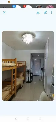 a room with bunk beds and a chandelier at Shell Condotel MOA Pasay in Manila