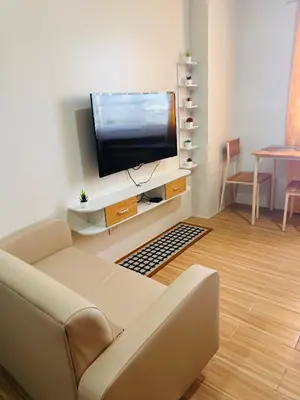 a living room with a couch and a flat screen tv at Tulip Garden condo in Biñan