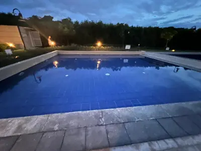 a swimming pool in a backyard at night at Tulip Garden condo in Biñan