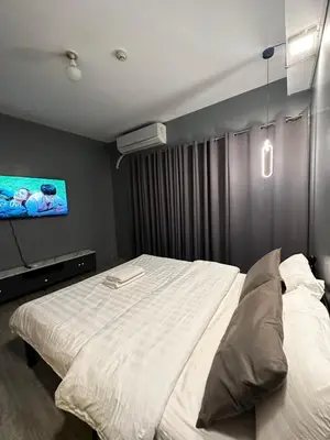 a bedroom with a large bed and a flat screen tv at Malate Bayview Mansion City View and Seaview Room in Manila