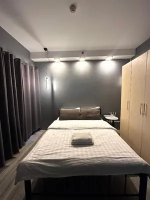 a bedroom with a large bed with lights on it at Malate Bayview Mansion City View and Seaview Room in Manila