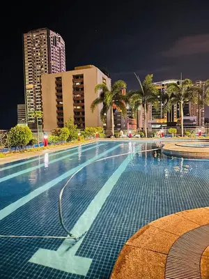 an empty swimming pool in a city at night at Malate Bayview Mansion City View and Seaview Room in Manila