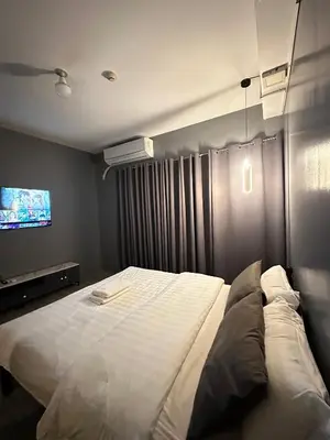a bedroom with a large white bed and a tv at Malate Bayview Mansion City View and Seaview Room in Manila
