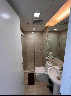 a bathroom with a shower and a toilet and a sink at Spacious Cozy Corner in Manila