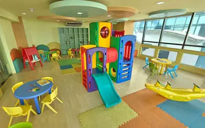 a room with a play area with tables and chairs at Spacious Cozy Corner in Manila