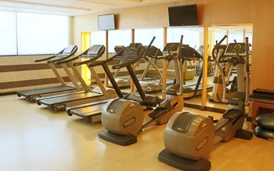 a gym with a bunch of tread machines in a room at Spacious Cozy Corner in Manila