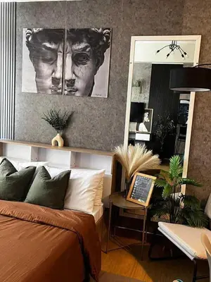 a bedroom with a bed and a portrait of a man at Meraki Stays - ISLA - SMDC Hope Residences in Trece Martires