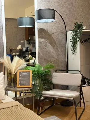 a room with a chair and a table with plants at Meraki Stays - ISLA - SMDC Hope Residences in Trece Martires