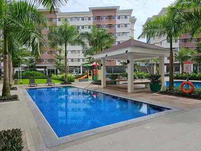 a swimming pool with a gazebo next to a building at Meraki Stays - ISLA - SMDC Hope Residences in Trece Martires