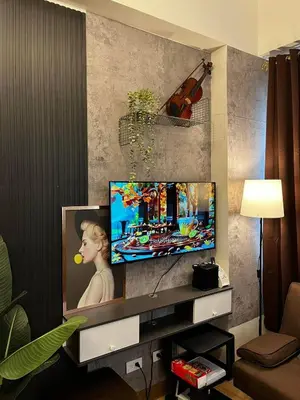 a living room with a flat screen tv on a wall at Meraki Stays - ISLA - SMDC Hope Residences in Trece Martires