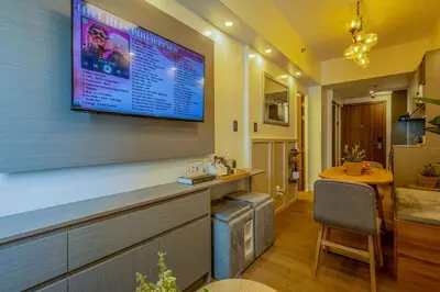 a living room with a large tv on the wall at Stylish Luxe 1 Bedroom Suite Near NAIA - FREE HIGH SPEED WIFI in Manila
