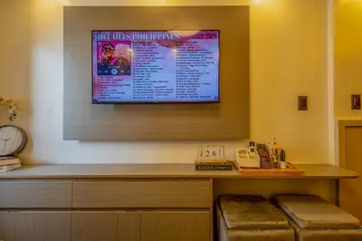 a flat screen tv hanging on a wall at Stylish Luxe 1 Bedroom Suite Near NAIA - FREE HIGH SPEED WIFI in Manila
