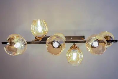 a light fixture with four lights and a glass bulb at Stylish Luxe 1 Bedroom Suite Near NAIA - FREE HIGH SPEED WIFI in Manila