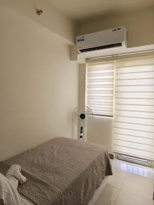 a bedroom with a bed with a fan and a window at Escape To Paradise in Manila