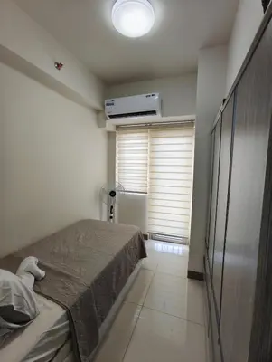 a small bedroom with a bed and a window at Escape To Paradise in Manila