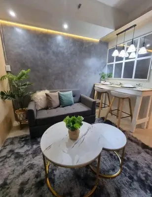 a living room with a couch and a table at Cozy Room At Sea Residences in Manila